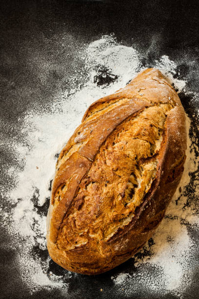 istock Rustic loaf of bread and flour on black chalkboard from above 1131834440