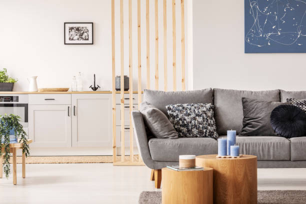 istock Open plan studio apartment with small white kitchen and living room with grey couch and wooden coffee table 1131834671