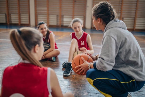 istock Female coach sitting with basketball team 1131834697