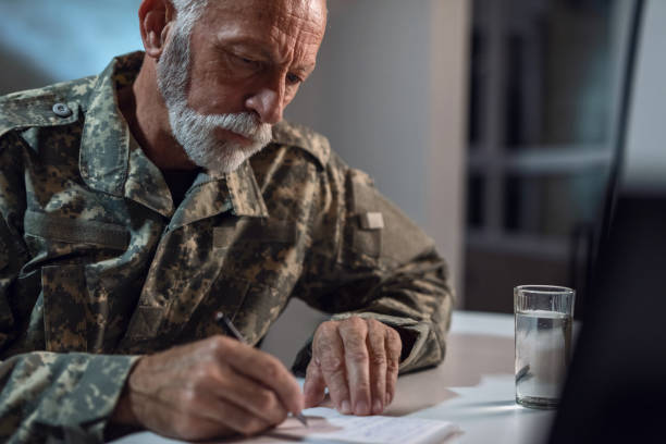 istock Serious mature soldier taking notes in the office. 1131834704