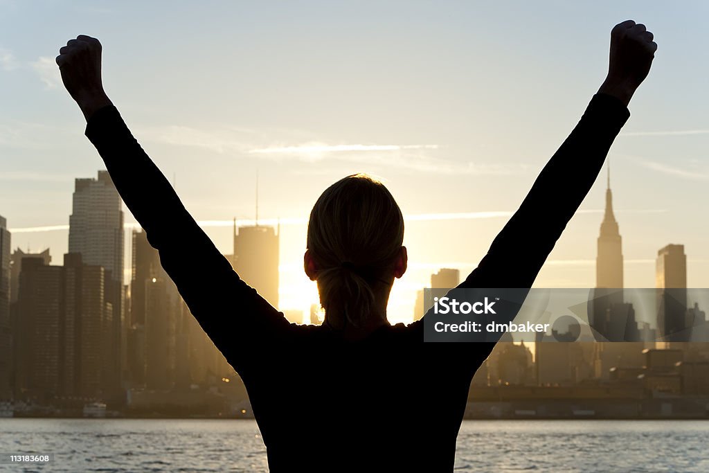 Woman お祝いの腕を上げるの日の出でニューヨーク市 - お祝いのロイヤリティフリーストックフォト