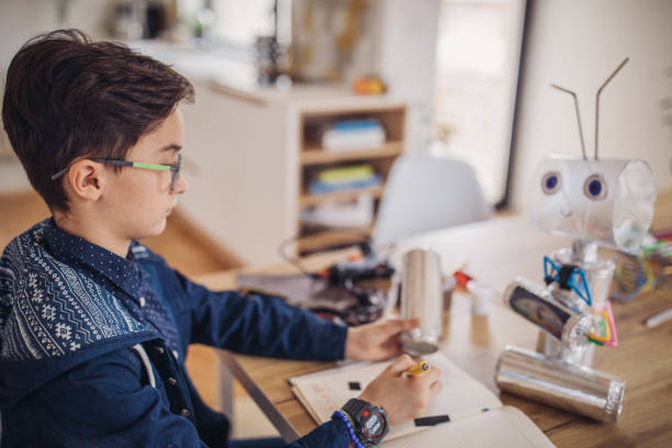 istock Little boy making robot toy of recycling material 1131836214