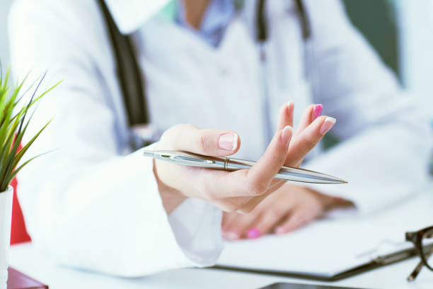 istock Female doctor explaining patient symptoms or asking a question as they discuss together in a consultation. Just hands over the table. 1131838720