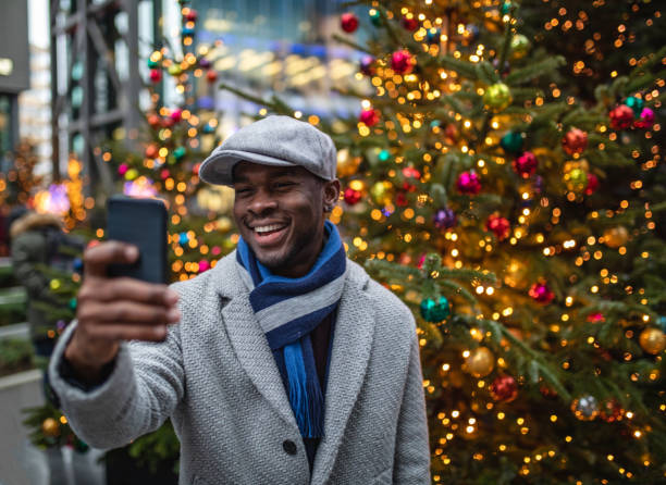 istock Beautiful black businessman doing a selfie with a Christmas tree 1131839722
