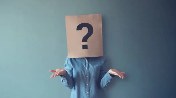 Photo of Woman has Confused, Thinking, Question Mark Icon on Paper Bag, copy space.