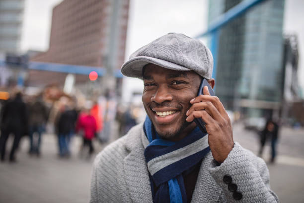 istock Beautiful black man with a cap talking on a mobile phone 1131841417