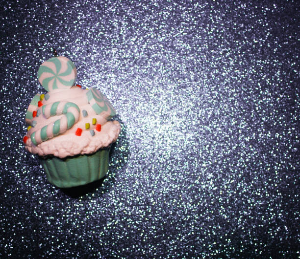 istock Blue cupcake on a glistening purple bokeh background. 1131849232