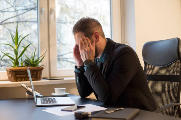 istock businessman working on laptop in office eyes hurt 1131850220