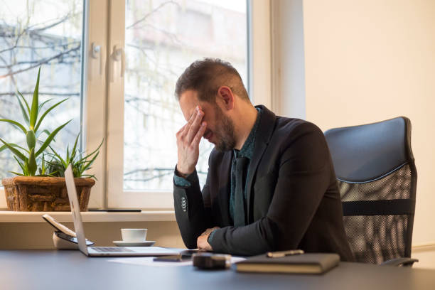 istock businessman working on laptop in office eyes hurt 1131850400