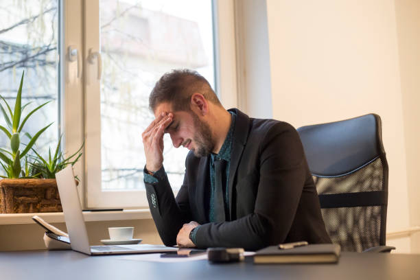istock businessman working on laptop in office headache 1131850483