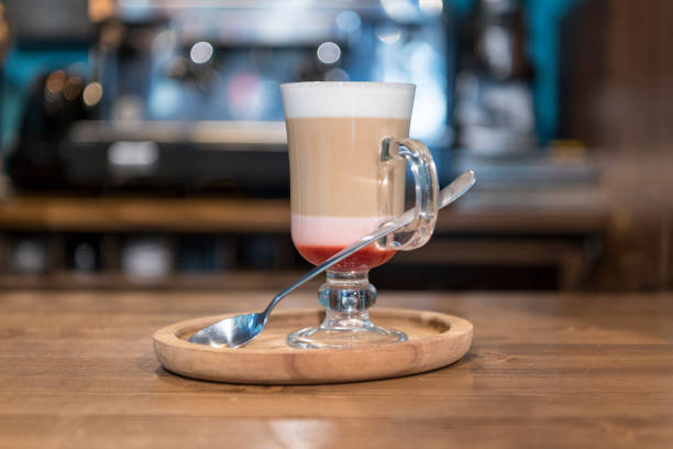 The hands of a young man make coffee from a coffee machine. Morning latte for breakfast at home. Homemade barista cappuccino in a stylish kitchen. Close up, place for text, copy space