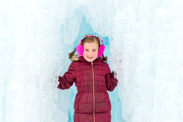 istock Pretty Girl Emerging from an Ice Cave Surrounded by Icicles 1131853086