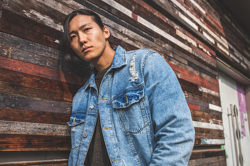 Handsome Asian man with long hair and denim jacket  portrait