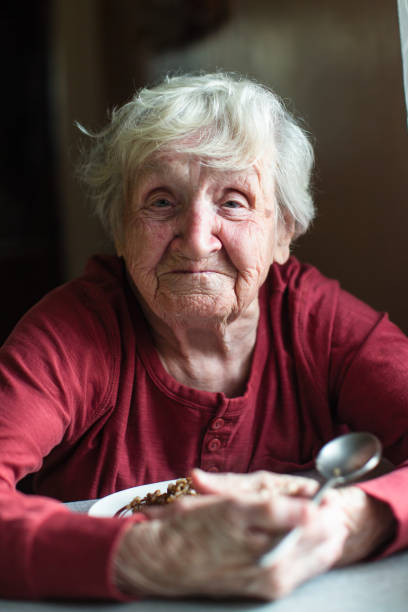 istock Portrait of elderly woman eats sitting at the table. 1131854543