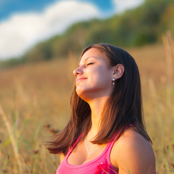 istock Young smiling woman sitting on the meadow 1131855049