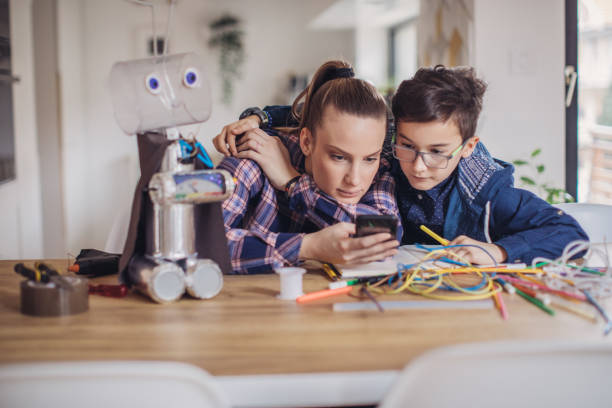 istock Boy making robot of recycling material with his older sister 1131855191