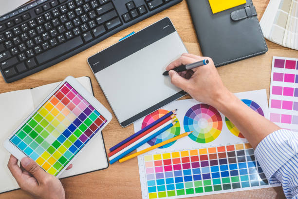 istock Image of male creative graphic designer working on color selection and drawing on graphics tablet at workplace with work tools and accessories in workspace 1131855236