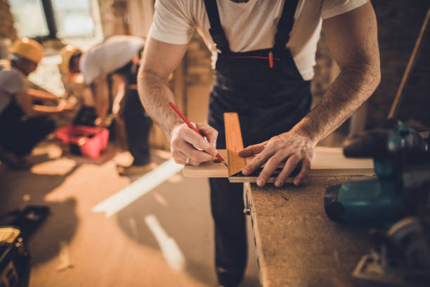 istock Unrecognizable worker drawing on wood plank at construction site. 1131856905
