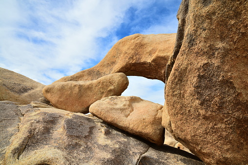 An arch rock formation of monzogranite in Joshua Tree National Park.