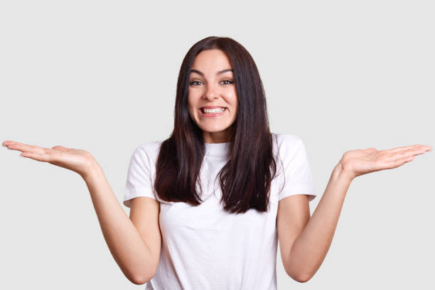 istock University student of model appearance on isolated background with gray tint does not know what kind of emotion to express, so she spreads her tanned hands in search of interesting inspiration. 1131860456