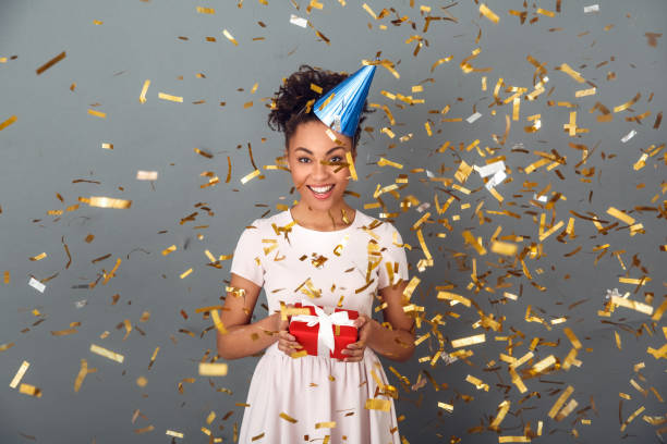 istock Young african woman isolated on grey wall studio celebration concept confetti burst 1131862888