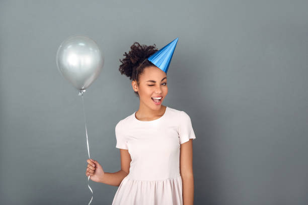 istock Young african woman isolated on grey wall studio celebration concept wink 1131863153