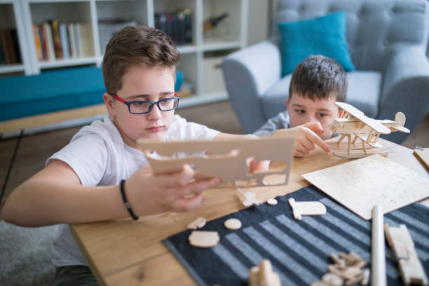 istock Brothers making wooden model plane for school project 1131866685