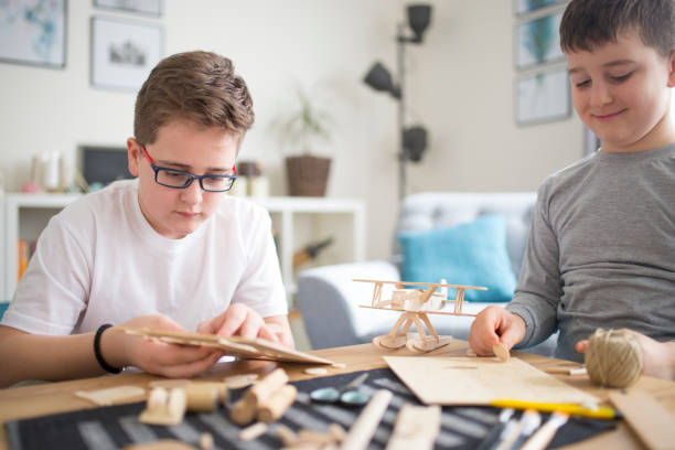istock Brothers making wooden model plane for school project 1131866818