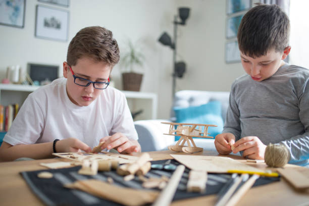 istock Brothers making wooden model plane for school project 1131866903
