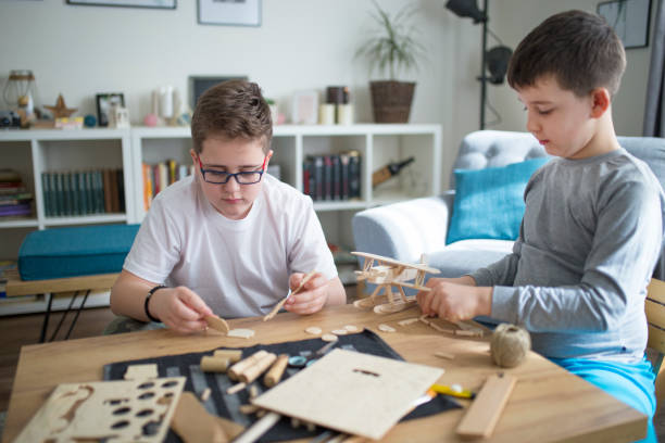 istock Brothers making wooden model plane for school project 1131866963