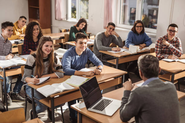 istock Smiling high school students listening to their teacher on a class. 1131867547