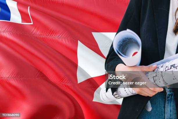 Architect Woman Holding Blueprint Against Wallis And Futuna Waving Flag Background Construction And Architecture Concept Stock Photo - Download Image Now