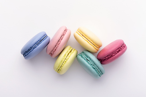 Colorful macarons on white background. Top view.