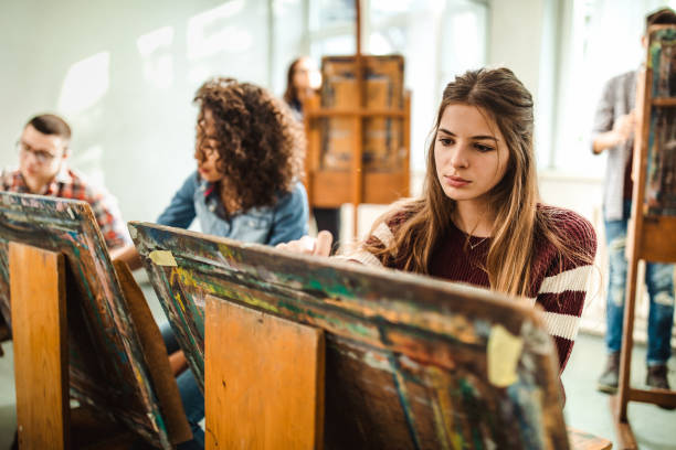 Group of students making their paintings on a class at art studio.
