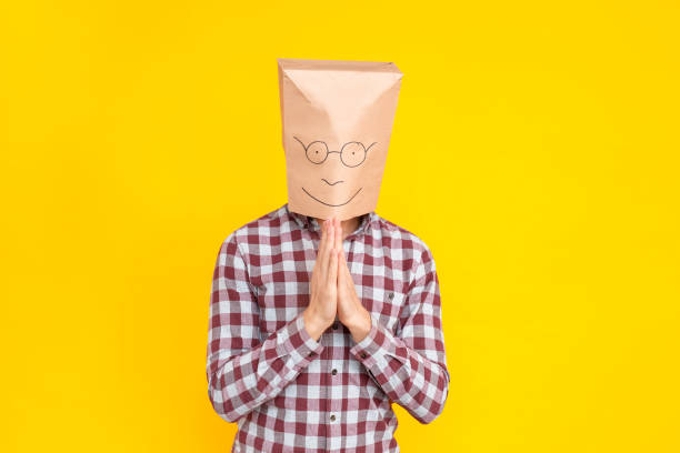 istock Man with a package on his head, showing please sign, apology 1131871389