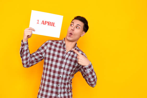 istock Man pointing finger at table with an inscription 1 april 1131871422