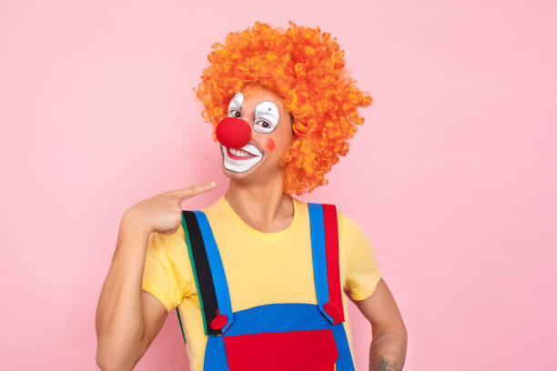 istock Proud man in a red wig, overalls and makeup pointing finger 1131871434
