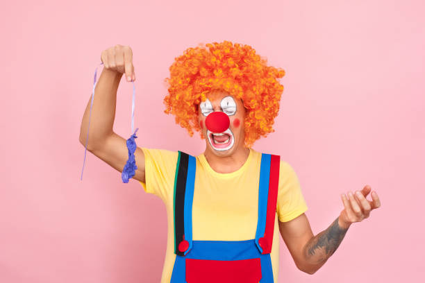 istock Balloon burst. Man in a red wig, overalls and makeup cry 1131871463