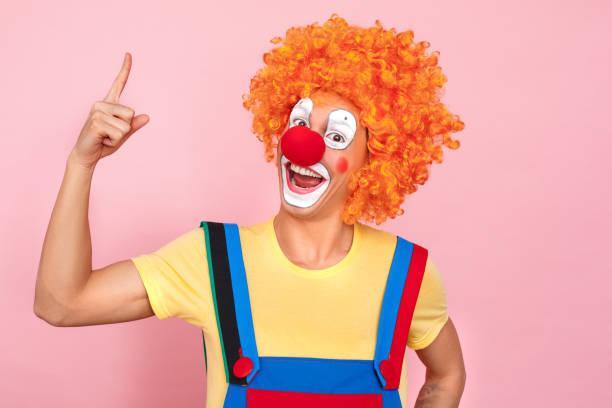 istock Man in a red wig, overalls and makeup finger up 1131871475