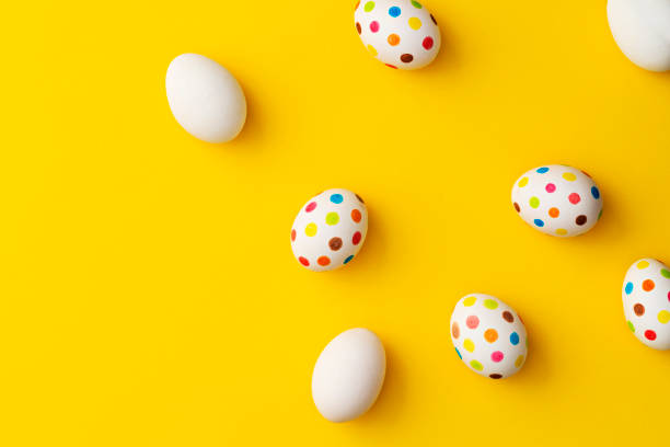 istock Spotty painted colourful easter eggs on yellow background. 1131871566