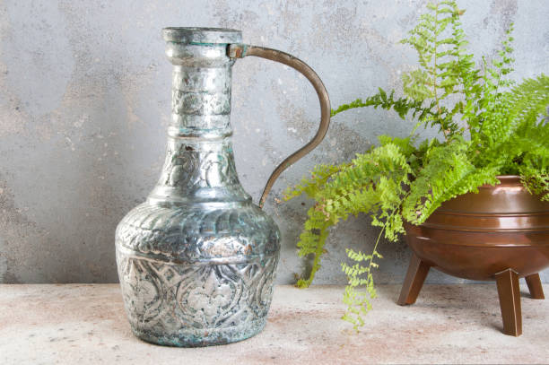 винтажный металлический кувшин и зеленое растение - fern flower pot plant decorative urn стоковые фото и изображения