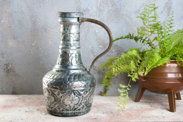 винтажная металлическая ваза и зеленое растение - fern flower pot plant decorative urn стоковые фото и изображения