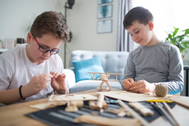 istock Brothers making wooden model plane for school project 1131873028