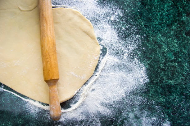 istock Dough on a floured marble green table, top view 1131873866
