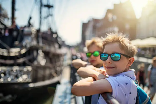 Brothers sightseeing Gdansk, Poland. They are walking in the city harbor and admiring the ships.
Nikon D850