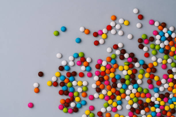 istock Colourful chocolate bean candies on grey background 1131875651