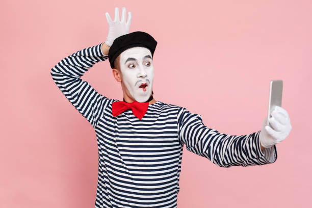 забавный мужчина в полосатом свитере, белые перчатки делают селфи фото - clown circus telephone humor стоковые фото и изображения