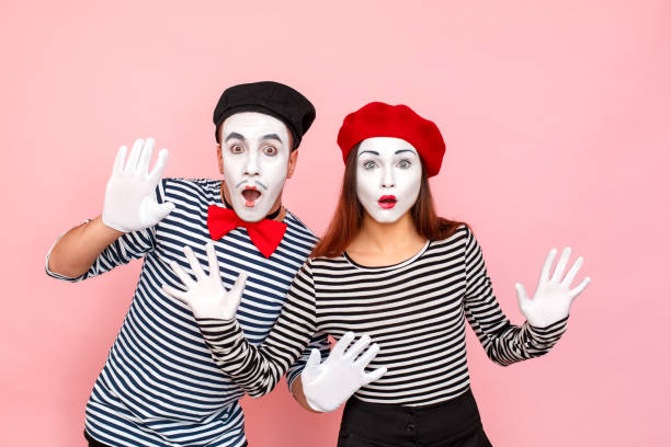 Closeup portrait of handsome couple with shocked face Closeup portrait of handsome couple with shocked face. Clown, artist , pantomime . Studio shot, pink background pantomime stock pictures, royalty-free photos & images