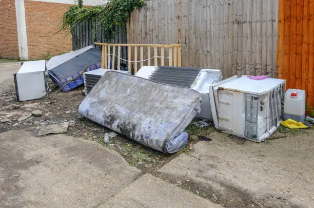 Large kitchen items dumped in an alleyway.  Fridge, freezer and matress. Fly tipping is an anti-social habit that is a modern scourge in our society.