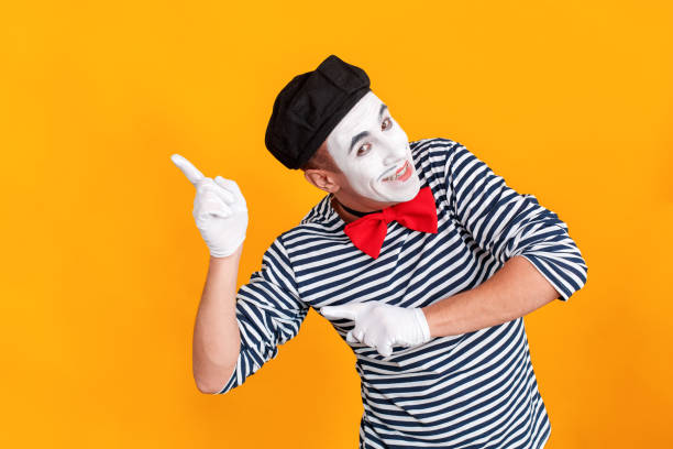 istock Mime man pointing fingers at copy space and toothy smiling 1131878390